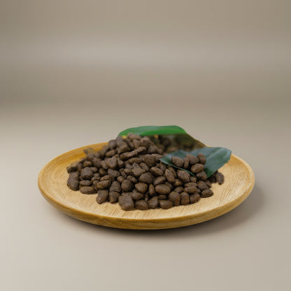 Lupiora Natural Greatness Lachs Trockenfutter für kleine Hunde auf einem Holzteller mit grünen Blättern.