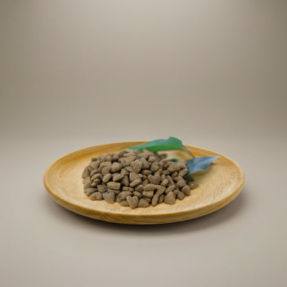 Lupiora NATURAL GREATNESS Sensitive Indoor Katzenfutter in Herzform auf einem Holzteller mit grünem Blatt